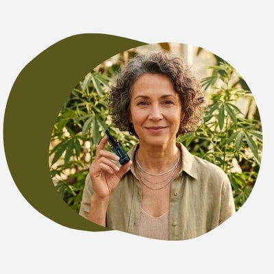 Femme mature apaisée utilisant de l'huile de CBD pour soulager les symptômes de la ménopause.