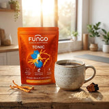 sachet (voir photo jointe), posé sur un plan de travail de cuisine À côté du pot, une belle tasse en céramique contient une boisson riche à base de chicorée torréfiée foncée, d'où s'échappe une légère vapeur. Près de la tasse, des éléments naturels et organiques sont disposés avec subtilité : un morceau de champignon Cordyceps séché, un petit fragment de Chaga et un léger saupoudrage de poudre de Maca.