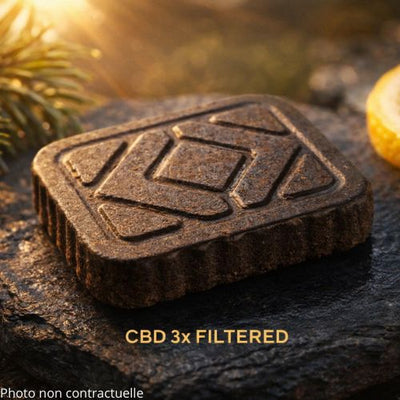premium CBD 3X Filtered hash block resting on a polished dark slate stone
