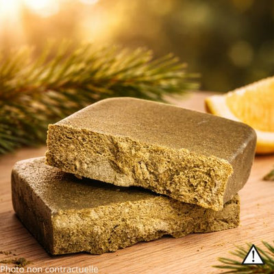 The resin has a soft, pliable, oily texture, dark brown on the outside and revealing a rich, lighter amber-blonde interior