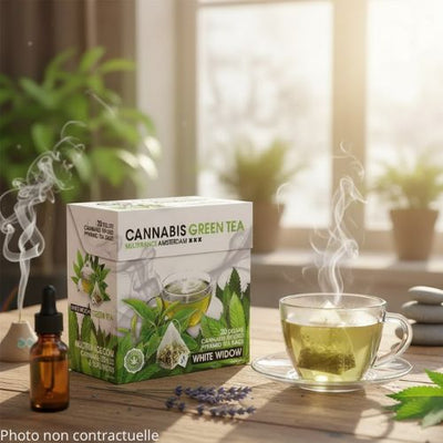BOITE DE CANNABIS GREEN TEA SUR UNE TABLE AVEC UNE TASSE DE THE PRESENTANT UN SACHET ET DE L'EAU CHAUDE